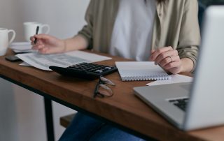 Mujer joven en su mesa de trabajo delante del portátil
